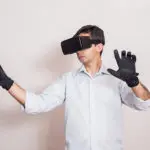 Haptique : Homme portant un masque et des gants de réalité virtuelle