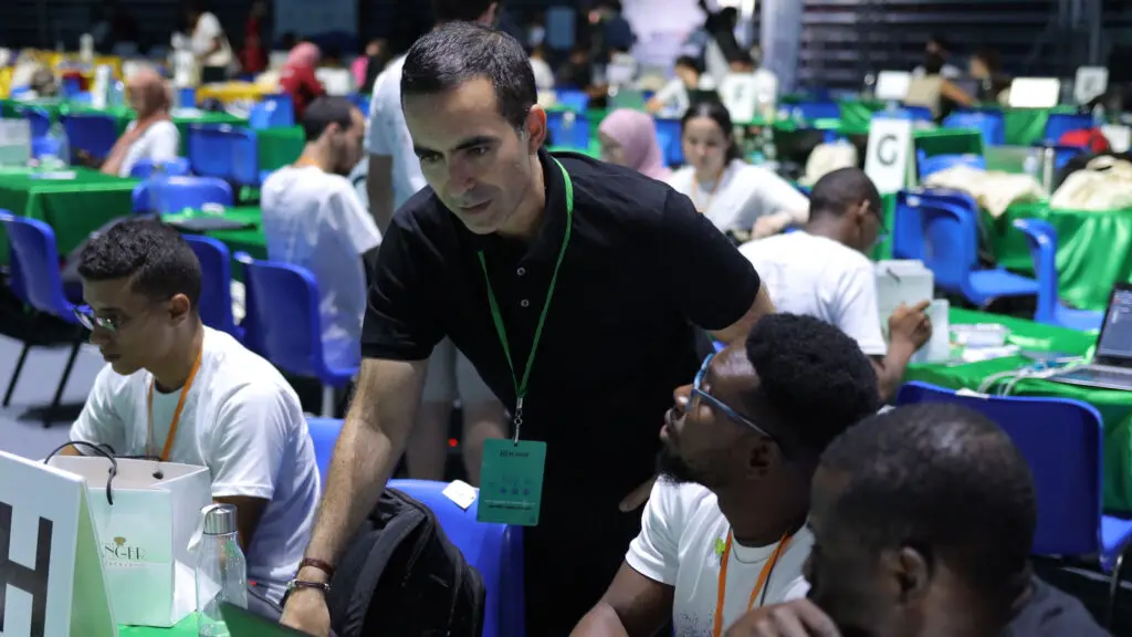 Karim aide des étudiants pendant AI Hack, un hackathon géant organisé en Tunisie.