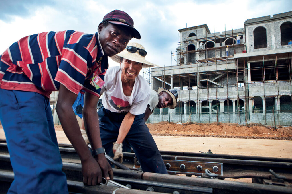 Travailleurs chinois et africains sur le chantier de construction d’une gare et d’un chemin de fer en Angola.